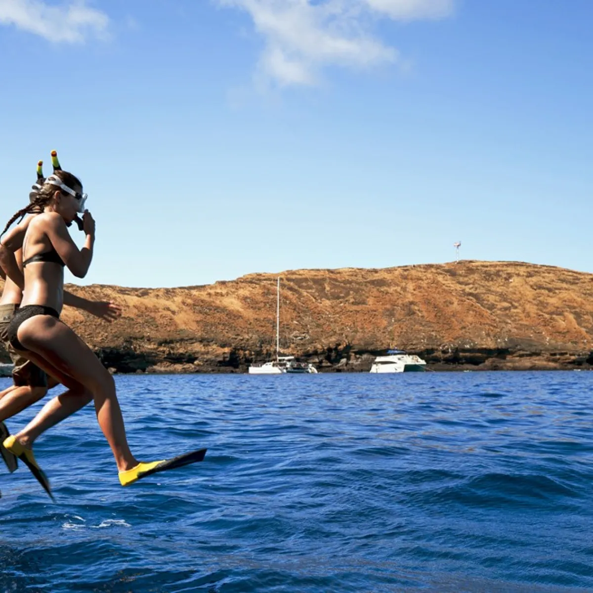 a person carrying a surf board on a body of water