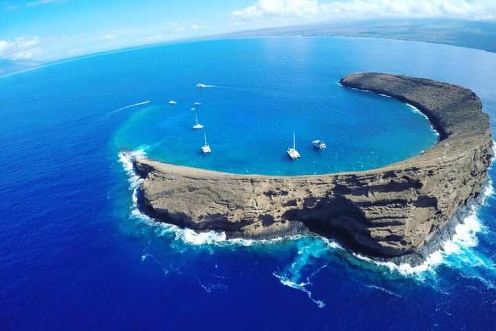a body of water with Molokini in the background