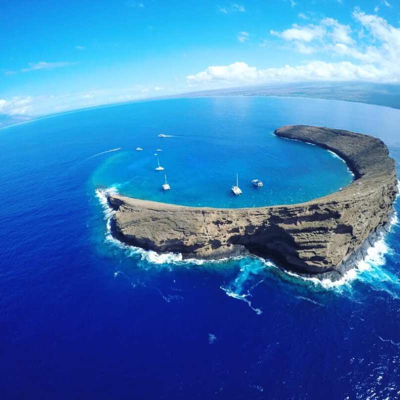 a body of water with Molokini in the background